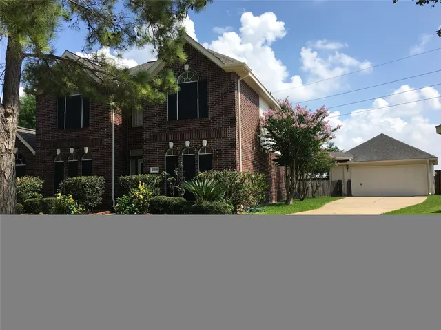 a front view of a house with a yard and a garden