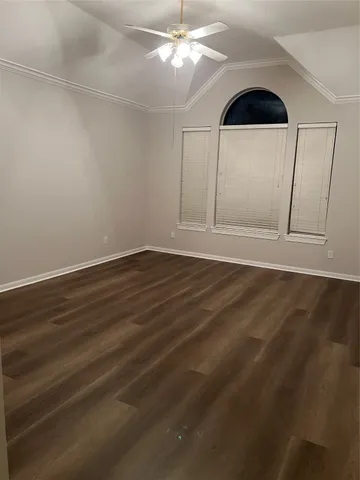 a view of an empty room with window and wooden floor