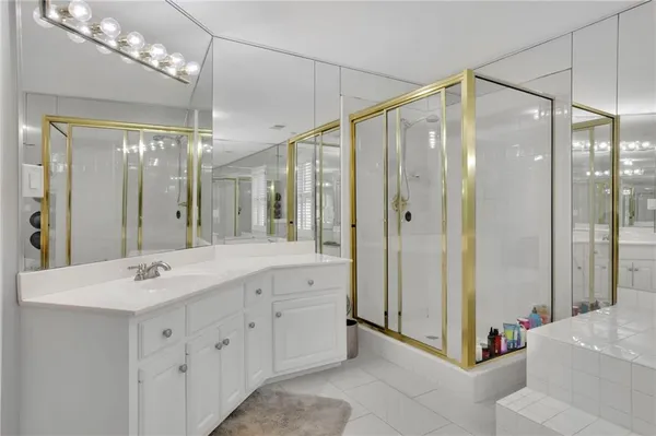 a bathroom with a tub a sink shower and a mirror