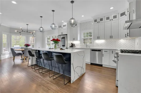 a kitchen with kitchen island granite countertop a sink cabinets and wooden floor