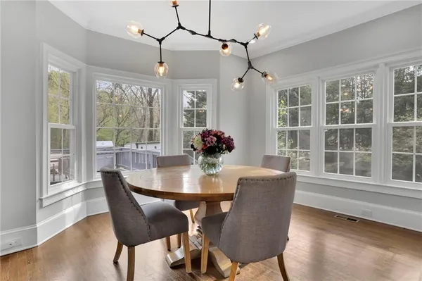 a dining room with furniture a chandelier and wooden floor