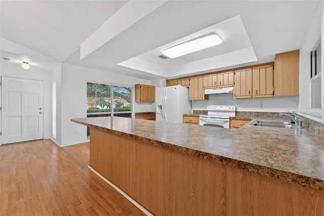 a dining room with wooden floor a chandelier a wooden table and chairs
