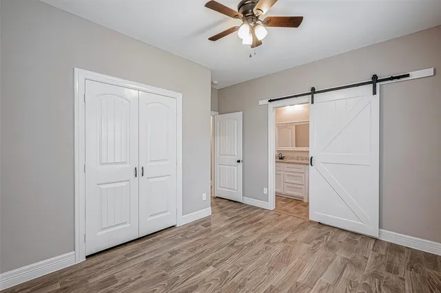 a view of a hallway with wooden floor and closet area