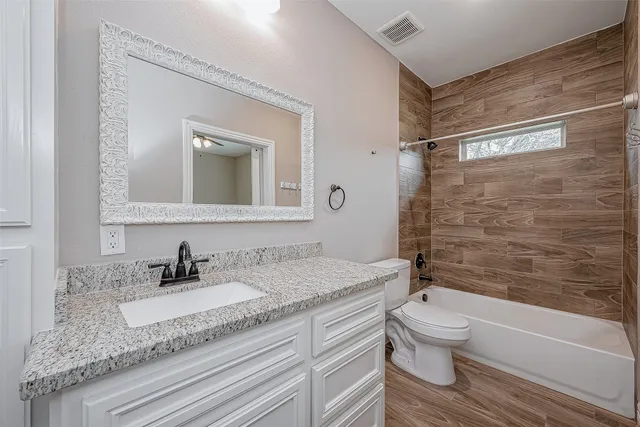 a bathroom with a granite countertop sink toilet and shower