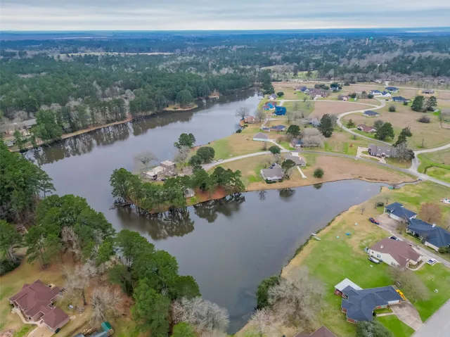 an aerial view of a house with outdoor space and a lake view