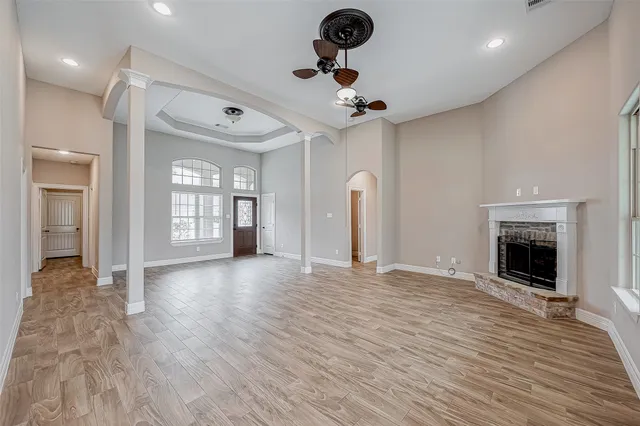 a view of an empty room with a fireplace and a window