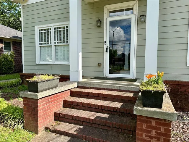 a front view of a house with a garden and patio