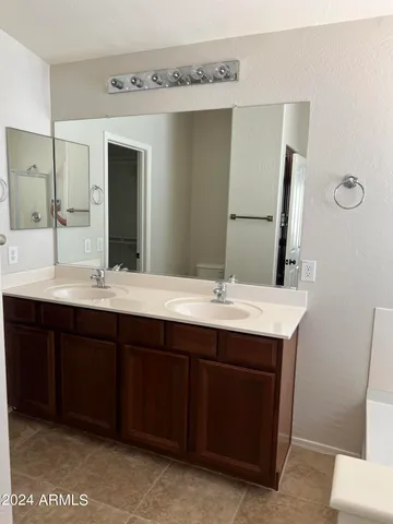 a bathroom with a double vanity sink and a mirror