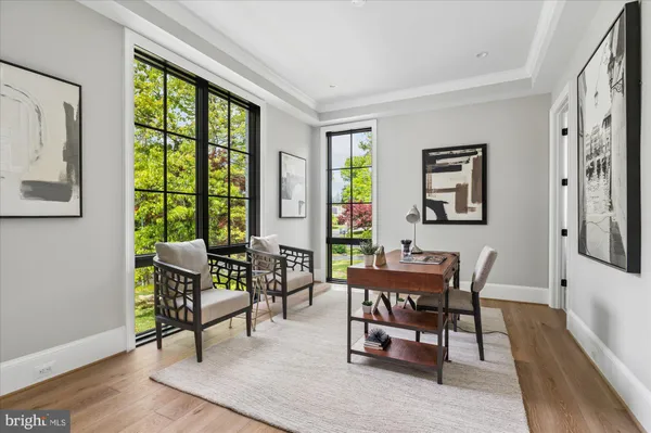 a view of staircase with lots of frames on wall and a dining table