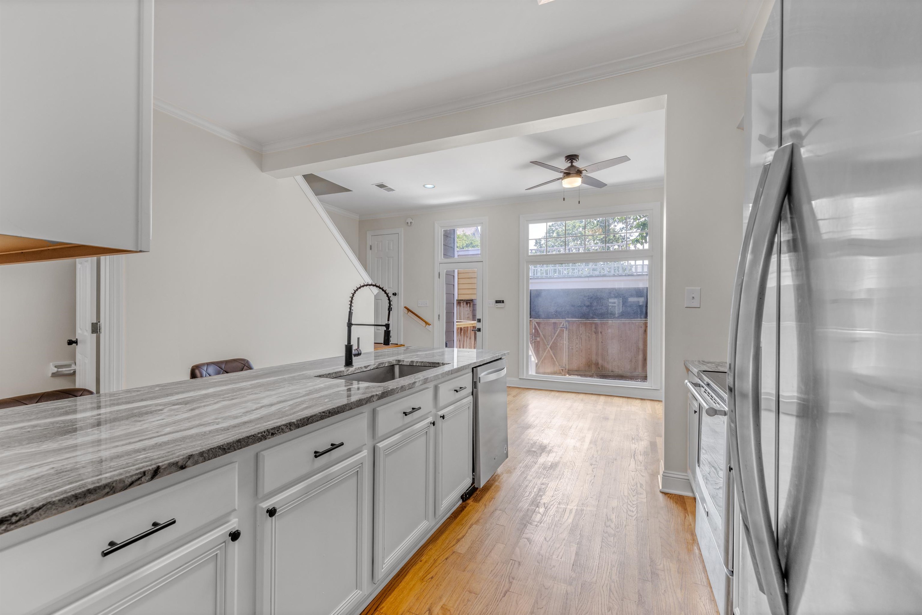 921 Harbor View Drive Memphis, TN 38103 - Photo 11 of 33 Kitchen featuring an undermount sink with a matte black faucet, white cabinetry with dark hardware, and a light-toned patterned countertop