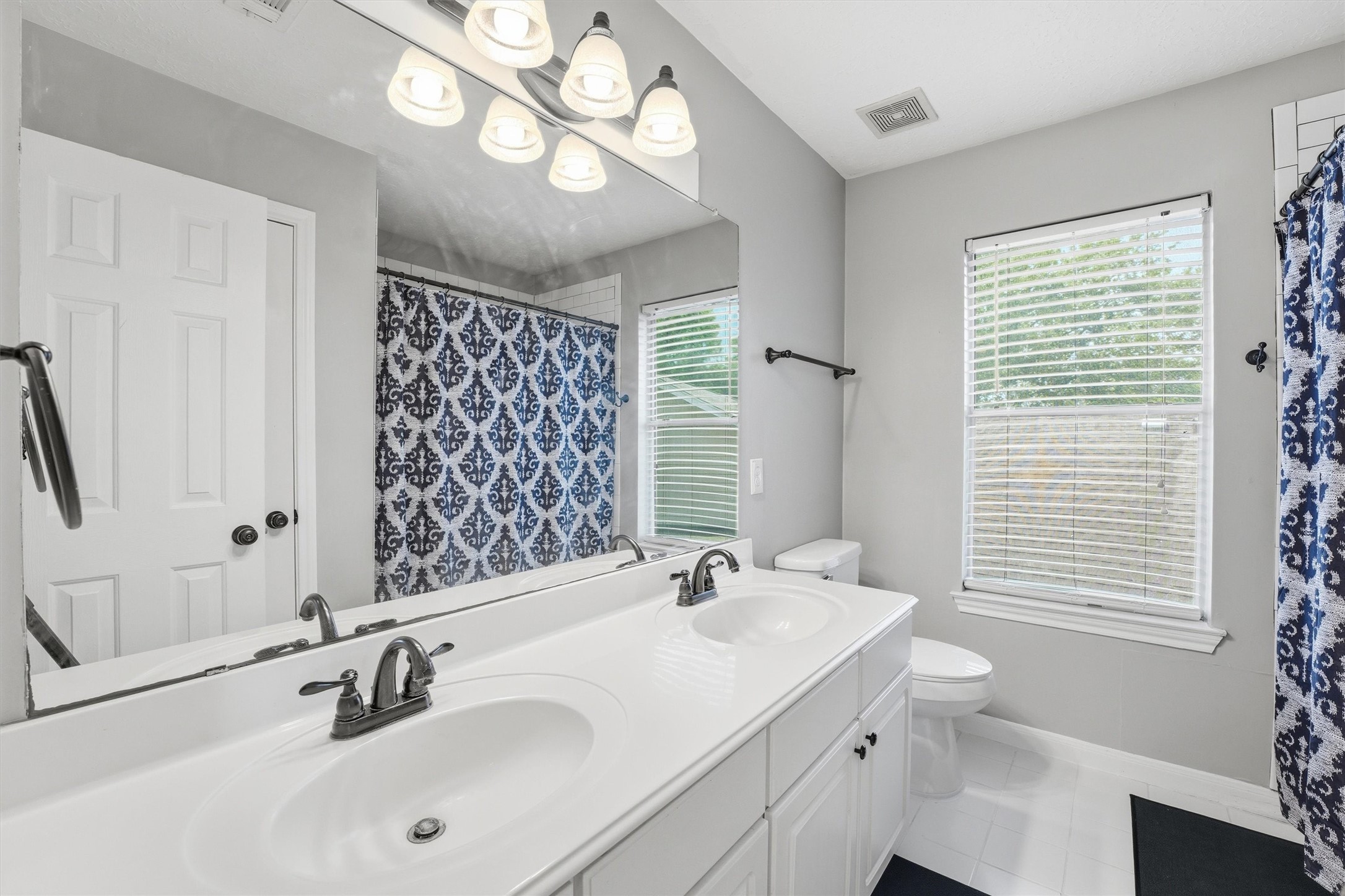 8827 Mile Run Road Humble, TX 77346 - Photo 23 of 37 a bathroom with a double vanity sink and a large mirror