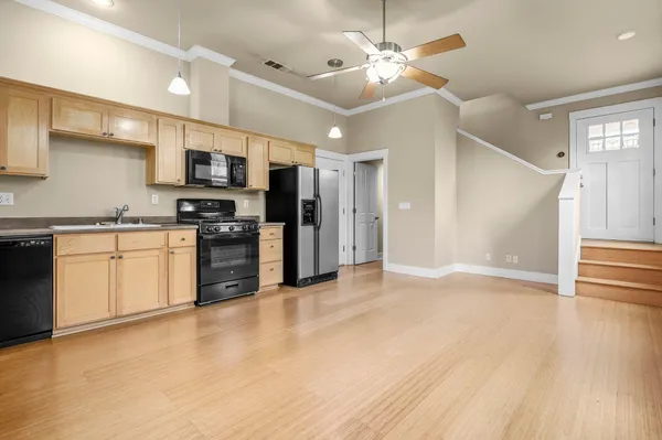 a view of kitchen with stainless steel appliances refrigerator stove microwave and cabinets