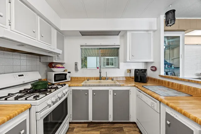a kitchen with a stove sink and cabinets