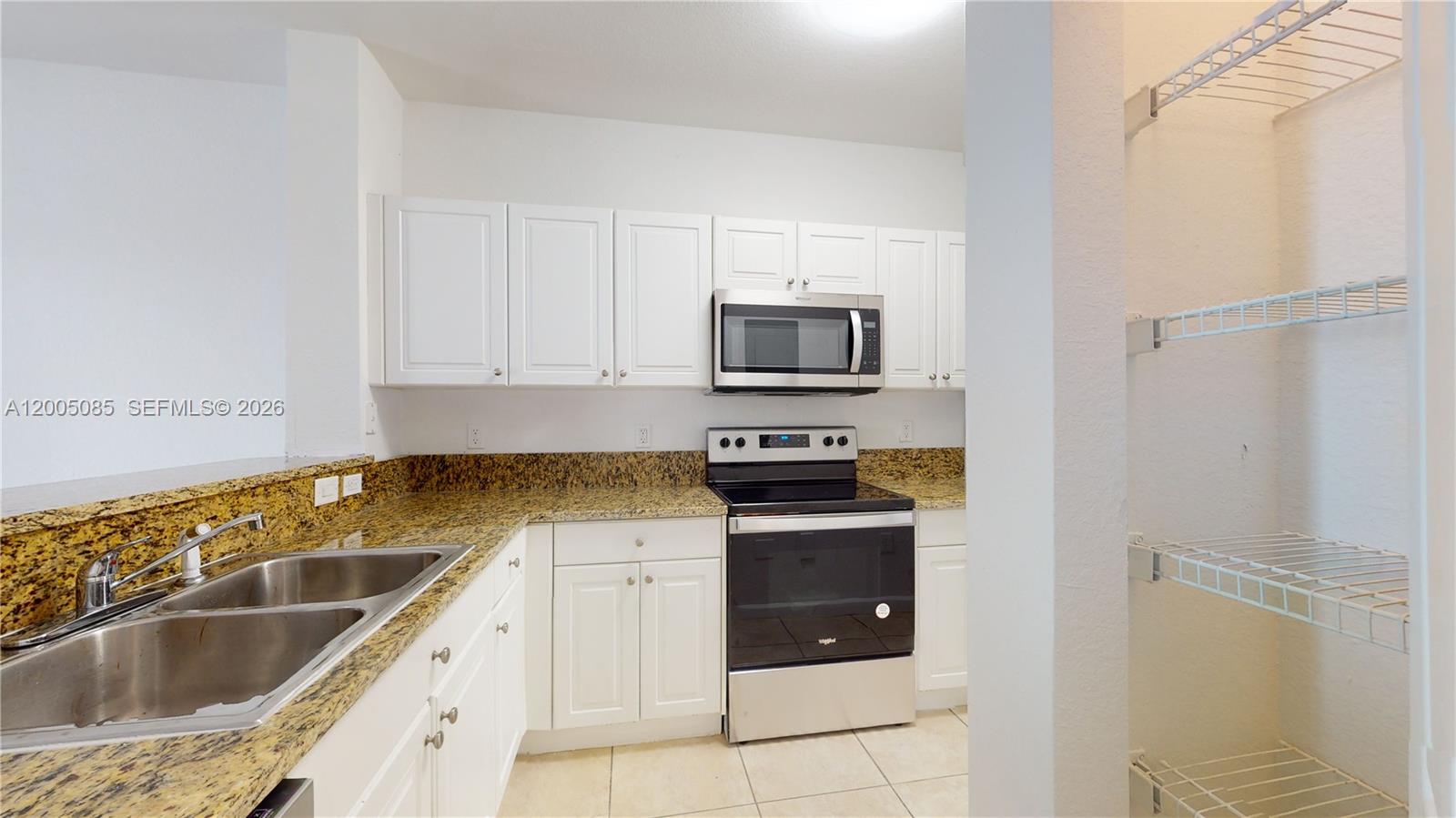 2929 Southeast 2nd Street, Unit 7 Homestead, FL 33033 - Photo 4 of 24 a kitchen with granite countertop a sink and a stove top oven