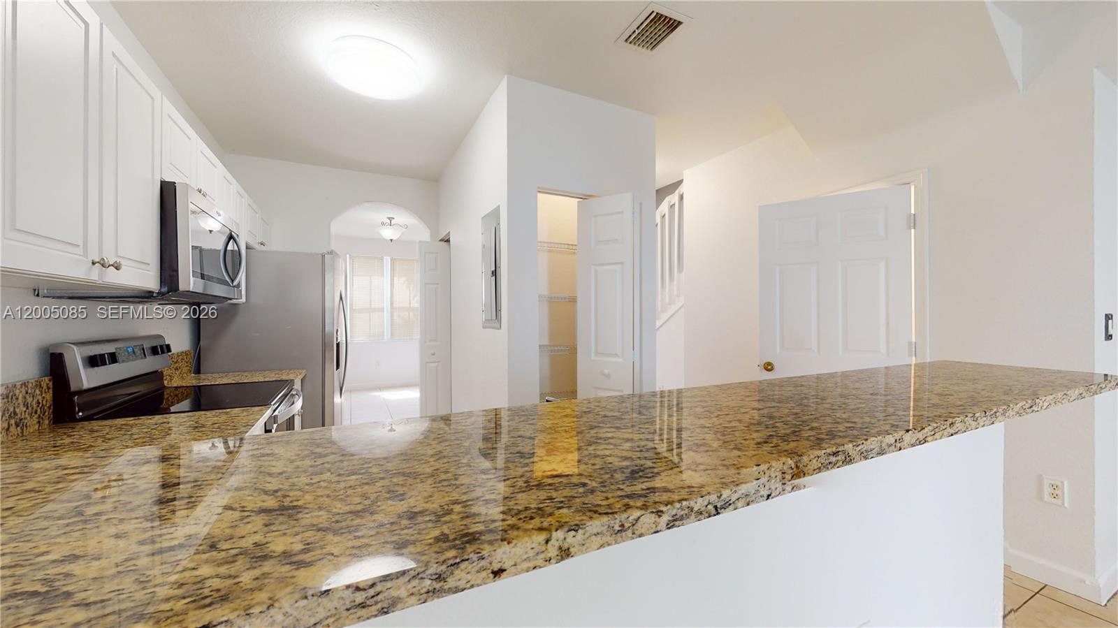 2929 Southeast 2nd Street, Unit 7 Homestead, FL 33033 - Photo 9 of 24 a kitchen with stainless steel appliances granite countertop a sink refrigerator and cabinets
