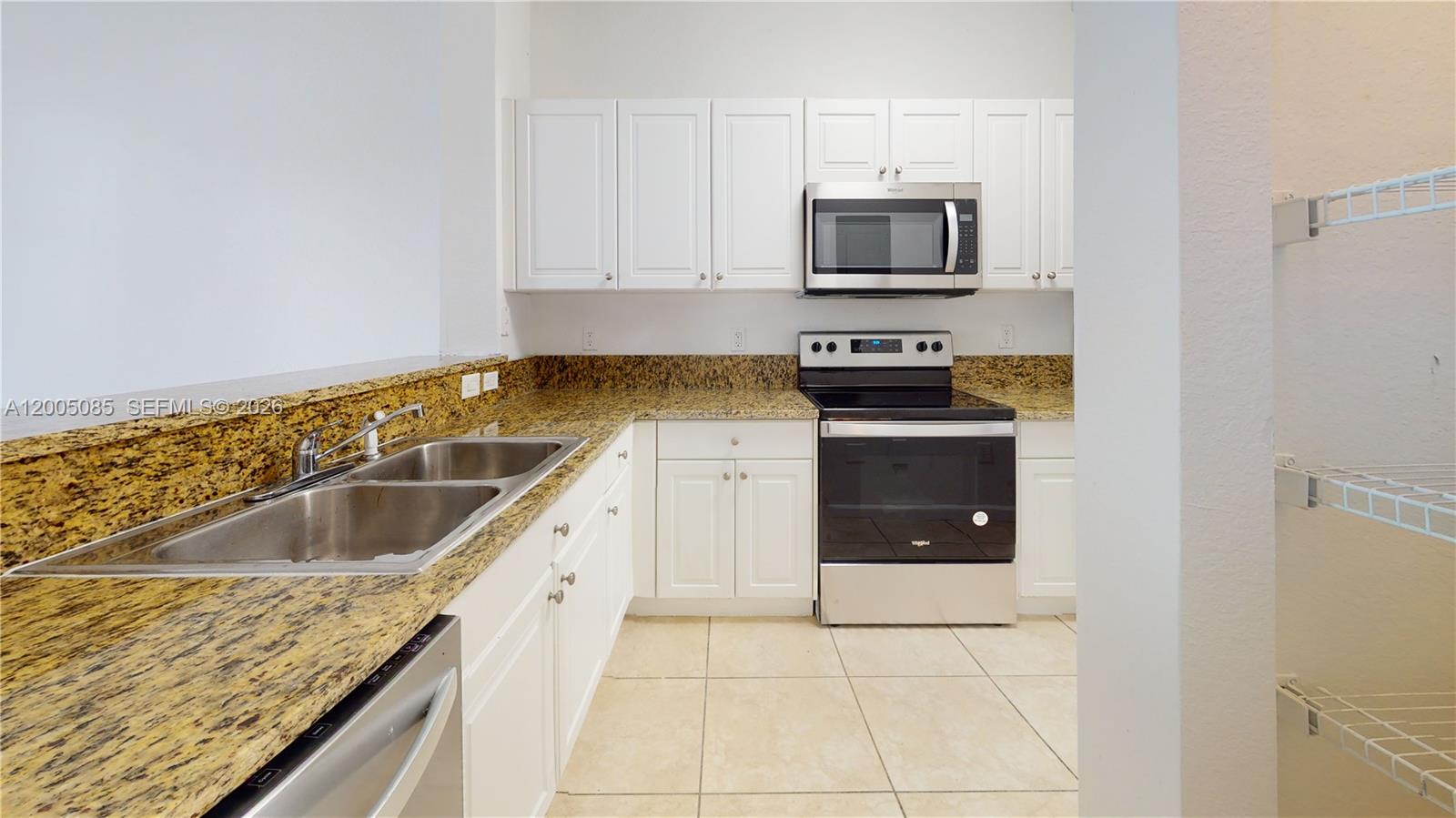 2929 Southeast 2nd Street, Unit 7 Homestead, FL 33033 - Photo 10 of 24 a kitchen with granite countertop white cabinets and stainless steel appliances