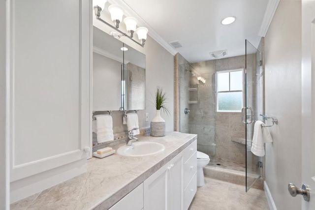 a bathroom with a granite countertop sink toilet and shower
