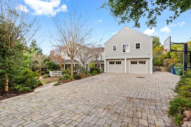 a front view of a house with a yard and trees