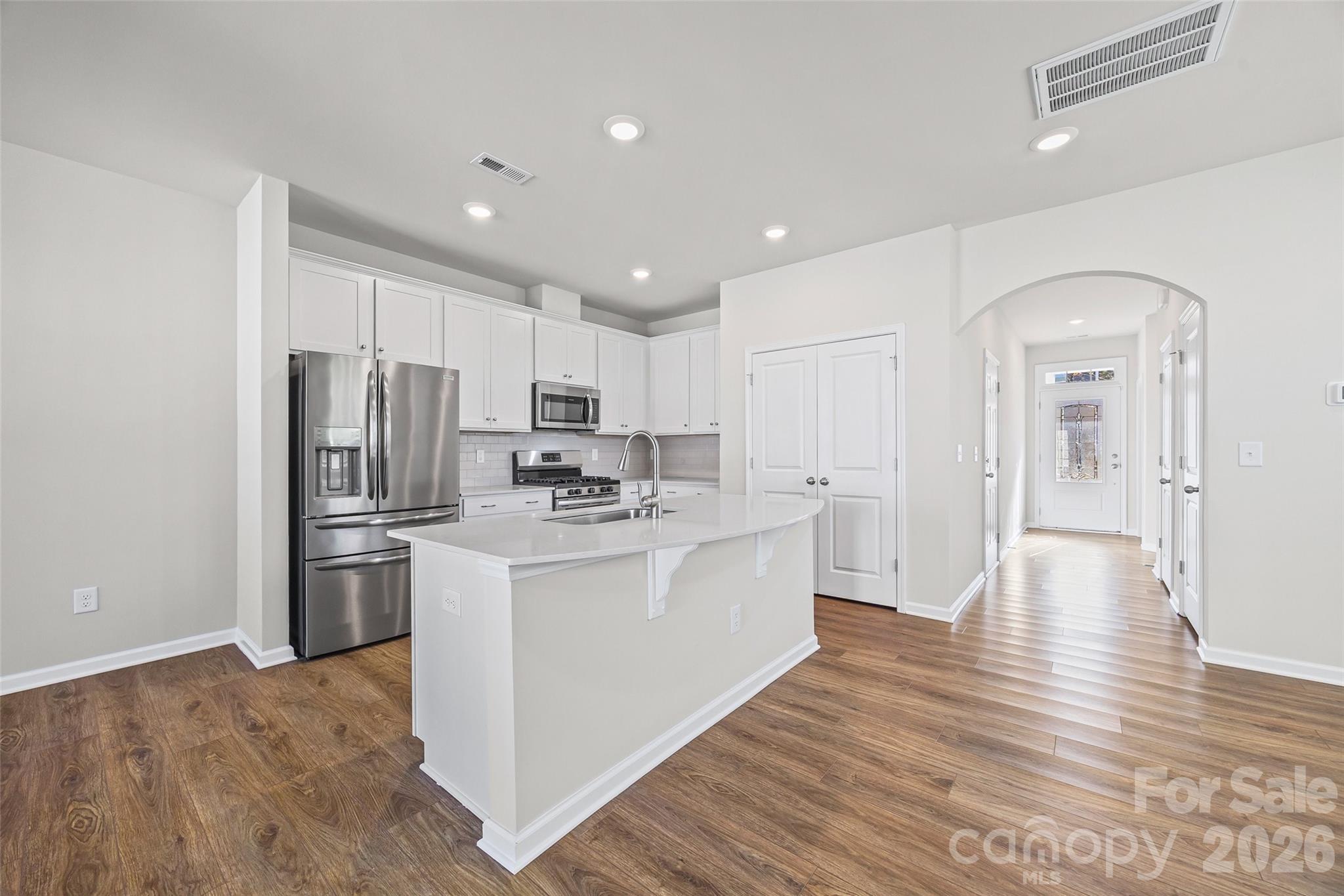 612 Rustic Path Lane Fort Mill, SC 29708 - Photo 11 of 38 a kitchen with stainless steel appliances granite countertop a refrigerator a stove oven a sink dishwasher and white cabinets with wooden floor