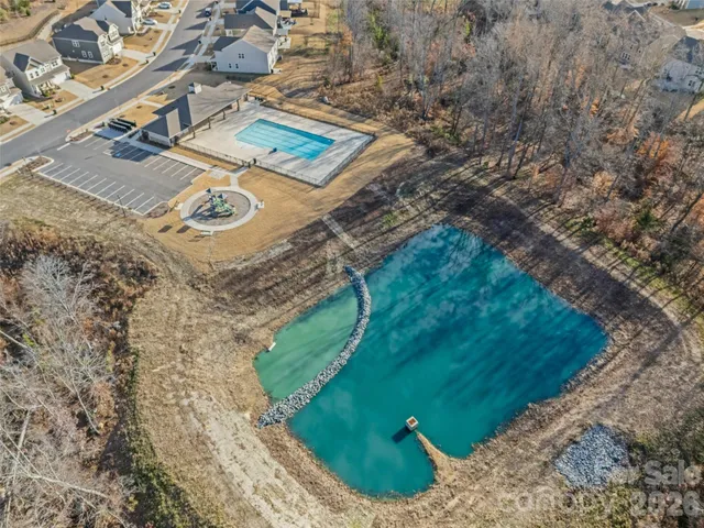 an aerial view of a house with swimming pool and green space
