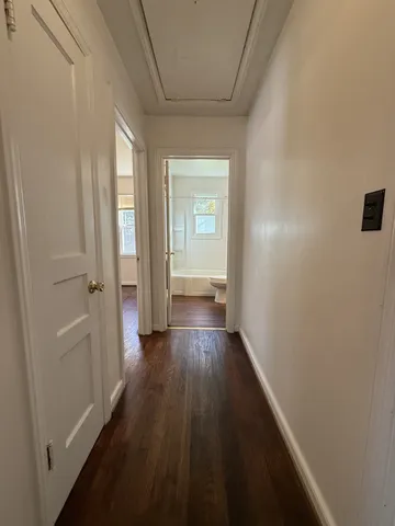 a view of a hallway with wooden floor and closet