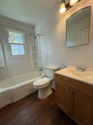 a bathroom with a double vanity sink a toilet and a bathtub