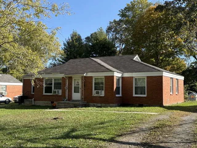 a big house with tree in front of it