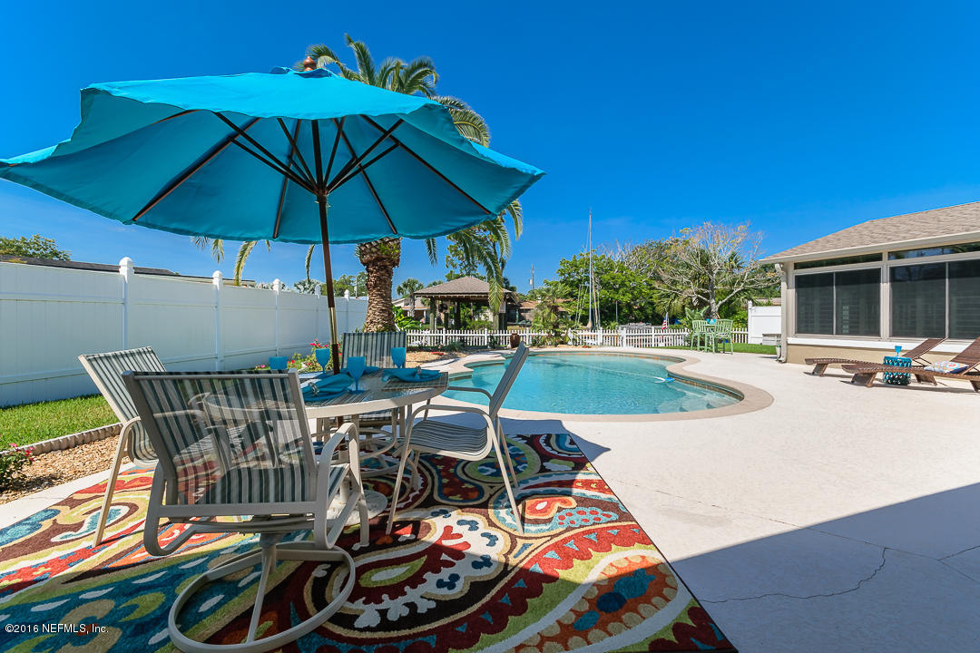 14446 Stacey Road Jacksonville, FL 32250 - Photo 13 of 31 a view of a patio with a dining table and chairs under an umbrella