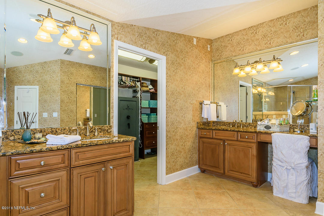 14446 Stacey Road Jacksonville, FL 32250 - Photo 23 of 31 a spacious bathroom with a granite countertop sink and a mirror