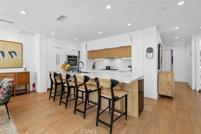 a large kitchen with stainless steel appliances granite countertop a large counter top and a view of living room