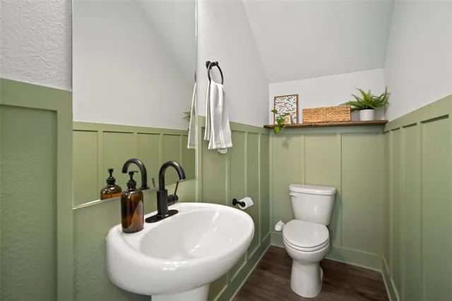a bathroom with a toilet sink and mirror