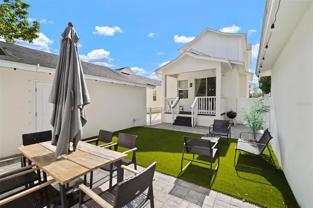 a view of a patio with table and chairs with wooden floor and fence