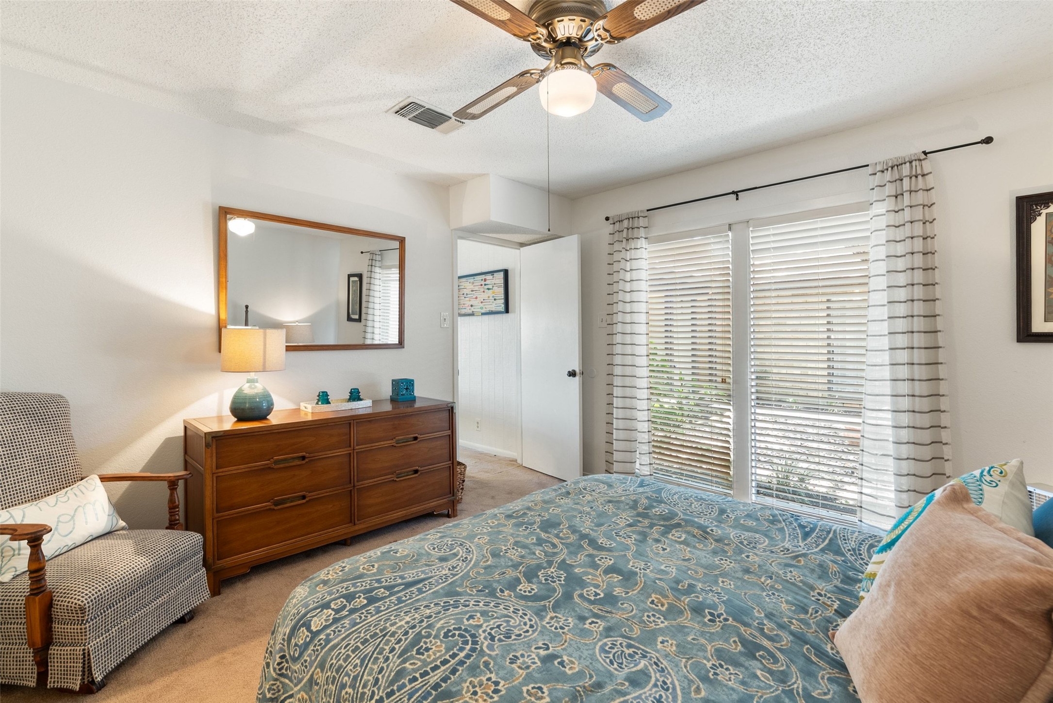 141 Perry Lane Kingsland, TX 78639 - Photo 29 of 40 Well-lit sleeping quarters with a ceiling fan, offering a tranquil retreat with views to the outdoors.