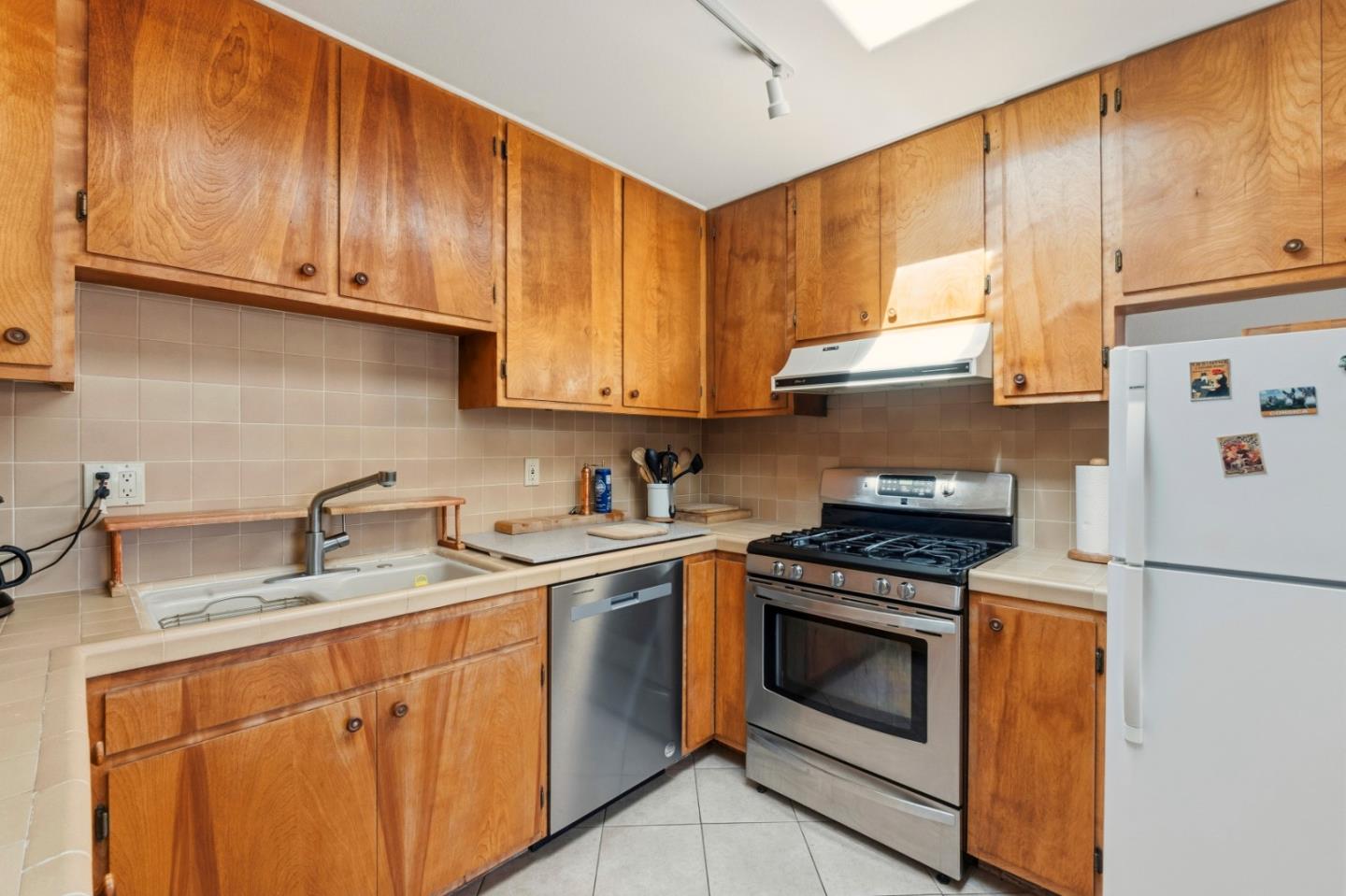 1313 Harding Street Seaside, CA 93955 - Photo 12 of 26 a kitchen with stainless steel appliances granite countertop a sink stove and refrigerator with wooden cabinets