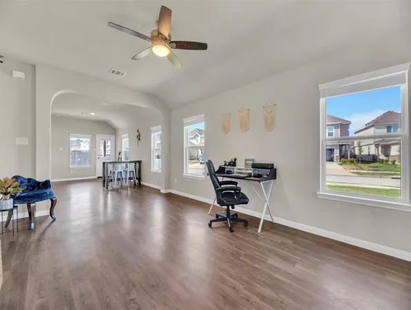 a view of a work space with wooden floor and a ceiling fan