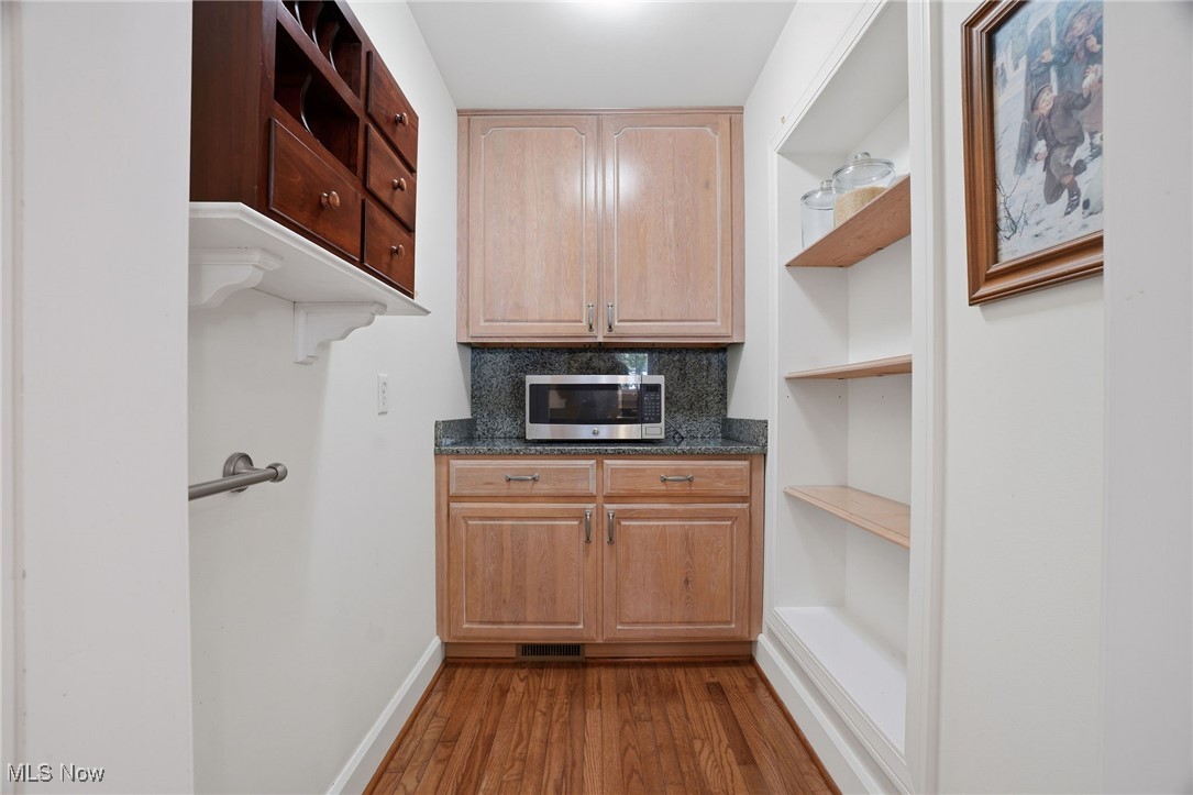 4441 Lake Road West Ashtabula, OH 44004 - Photo 10 of 46 Kitchen with open shelves, dark wood-style floors, stainless steel microwave, backsplash, and dark stone countertops