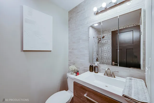 a bathroom with a sink vanity mirror and toilet