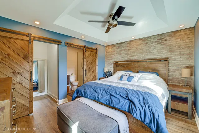 a bedroom with a bed a ceiling fan and a dresser