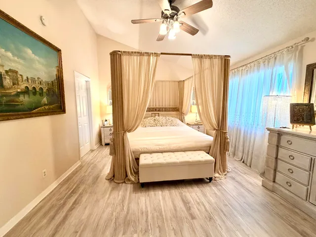 a spacious bedroom with a bed and a chandelier