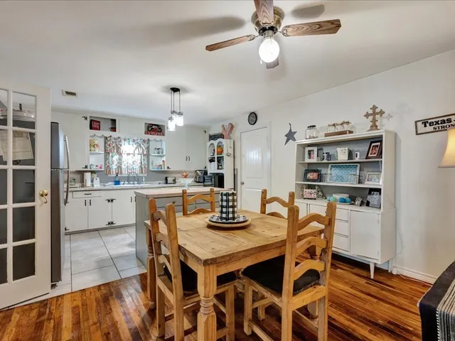 a kitchen with a dining table cabinets stainless steel appliances and dining table