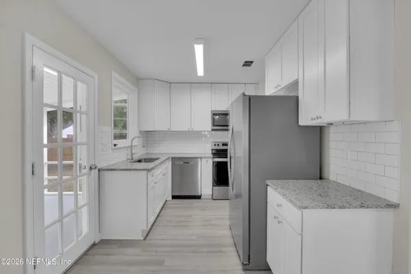a kitchen with a refrigerator a sink and wooden cabinets