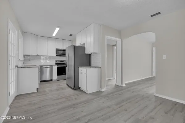 a kitchen with stainless steel appliances a refrigerator and a stove top oven