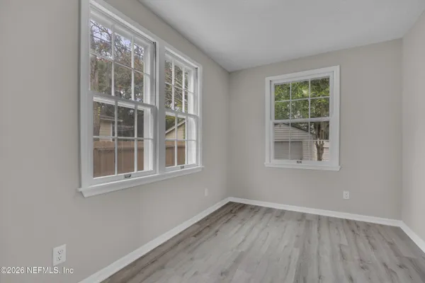 a view of empty room with wooden floor and fan