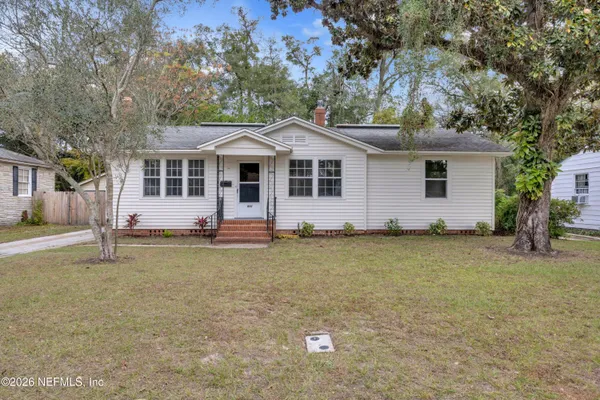 a backyard of a house with yard and tree