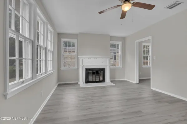 wooden floor fireplace and windows in an empty room
