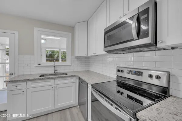 a kitchen with appliances a sink and cabinets