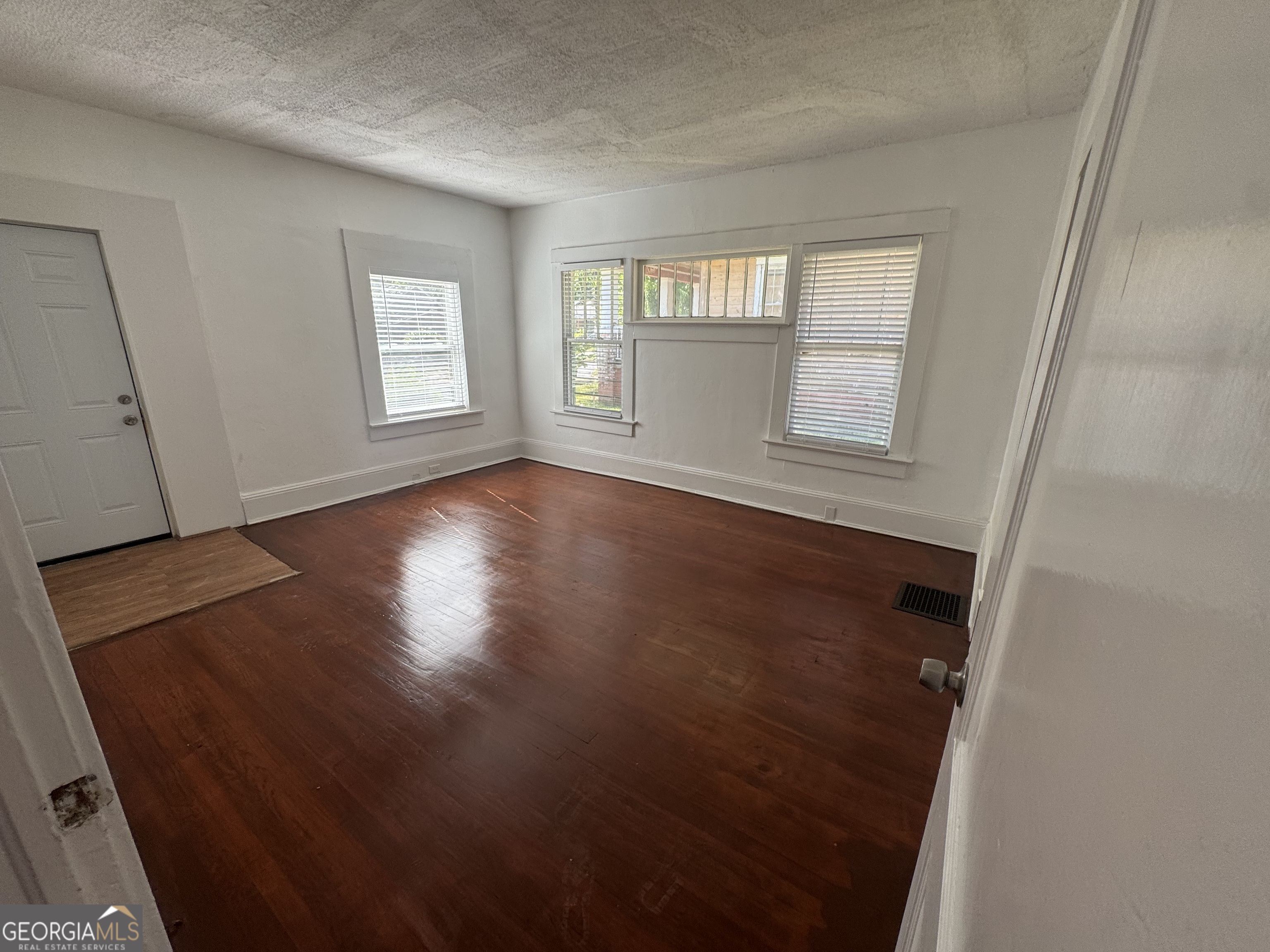 415 Hopkins Street Southwest Atlanta, GA 30310 - Photo 9 of 12 an empty room with wooden floor and windows