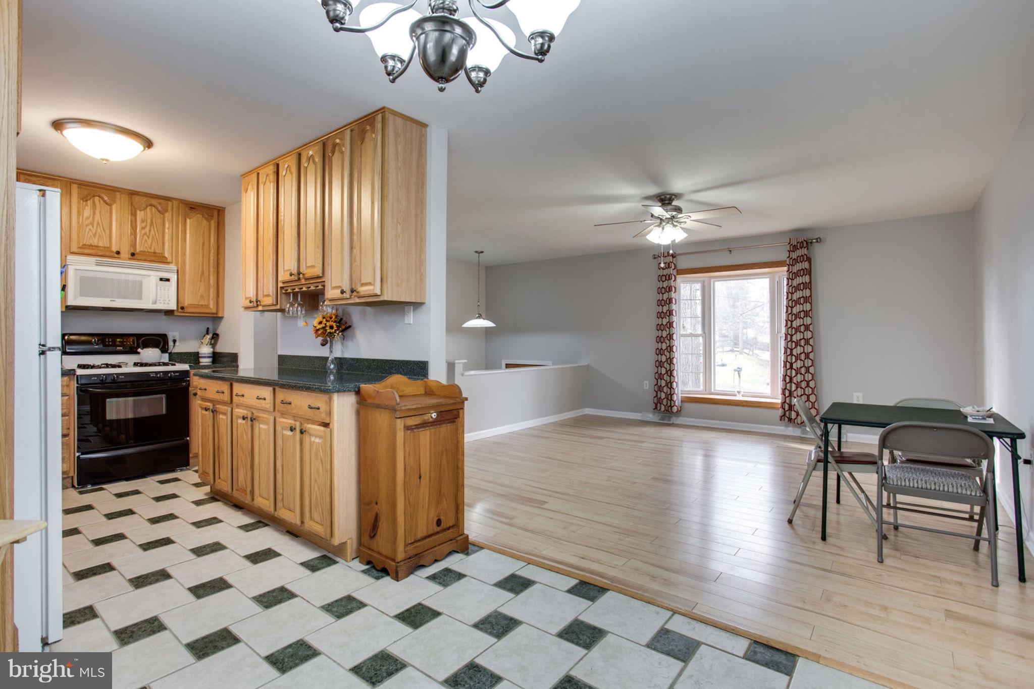 1625 Thomas Drive Point of Rocks, MD 21777 - Photo 14 of 47 a kitchen with stainless steel appliances granite countertop a stove top oven a sink a dining table and chairs with wooden floor