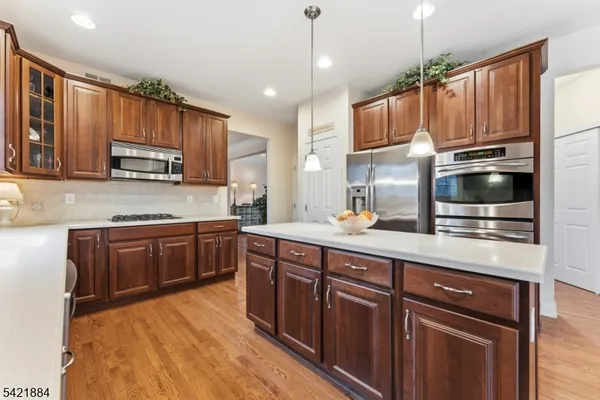 a kitchen with stainless steel appliances granite countertop wooden cabinets a stove top oven a sink and dishwasher