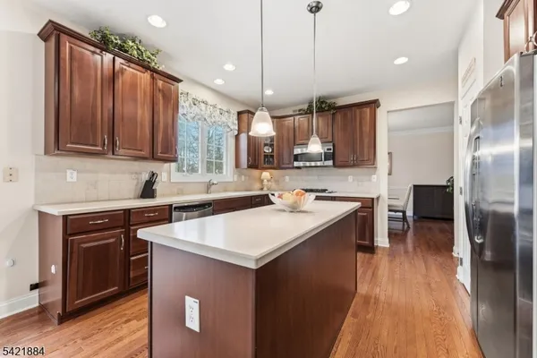 a kitchen with kitchen island granite countertop a sink appliances and cabinets